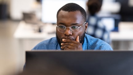 Individual sitting in office infront of his laptop